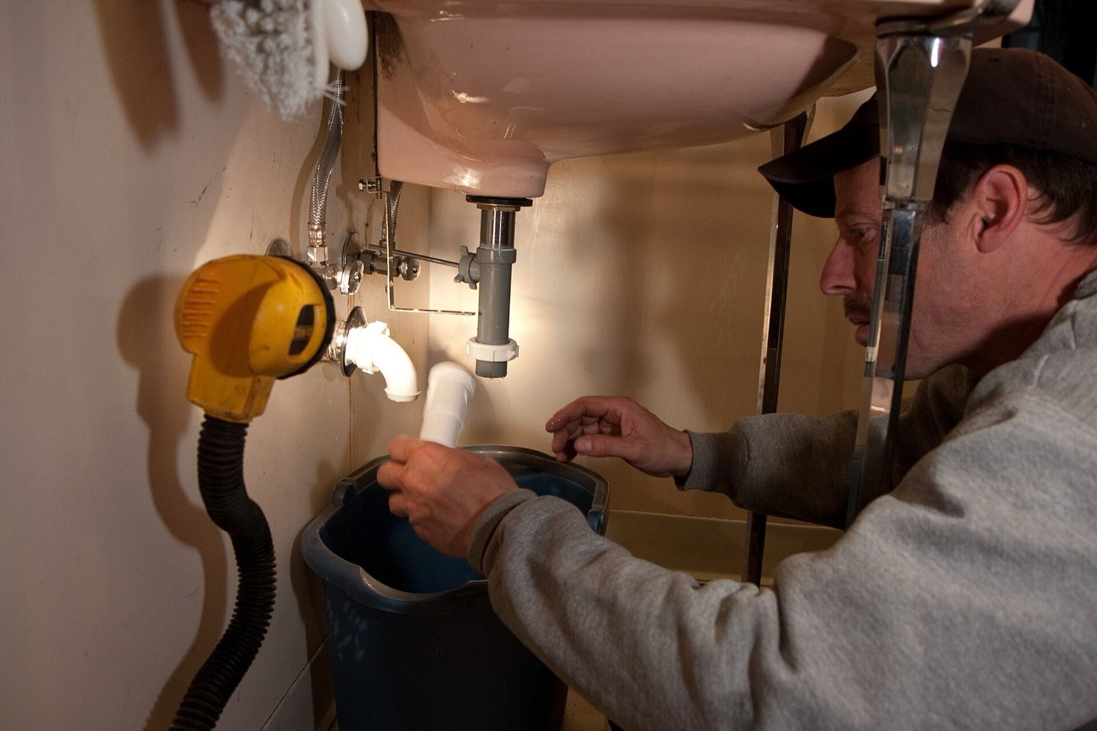Plombier travaillant sur un réseau de canalisations.